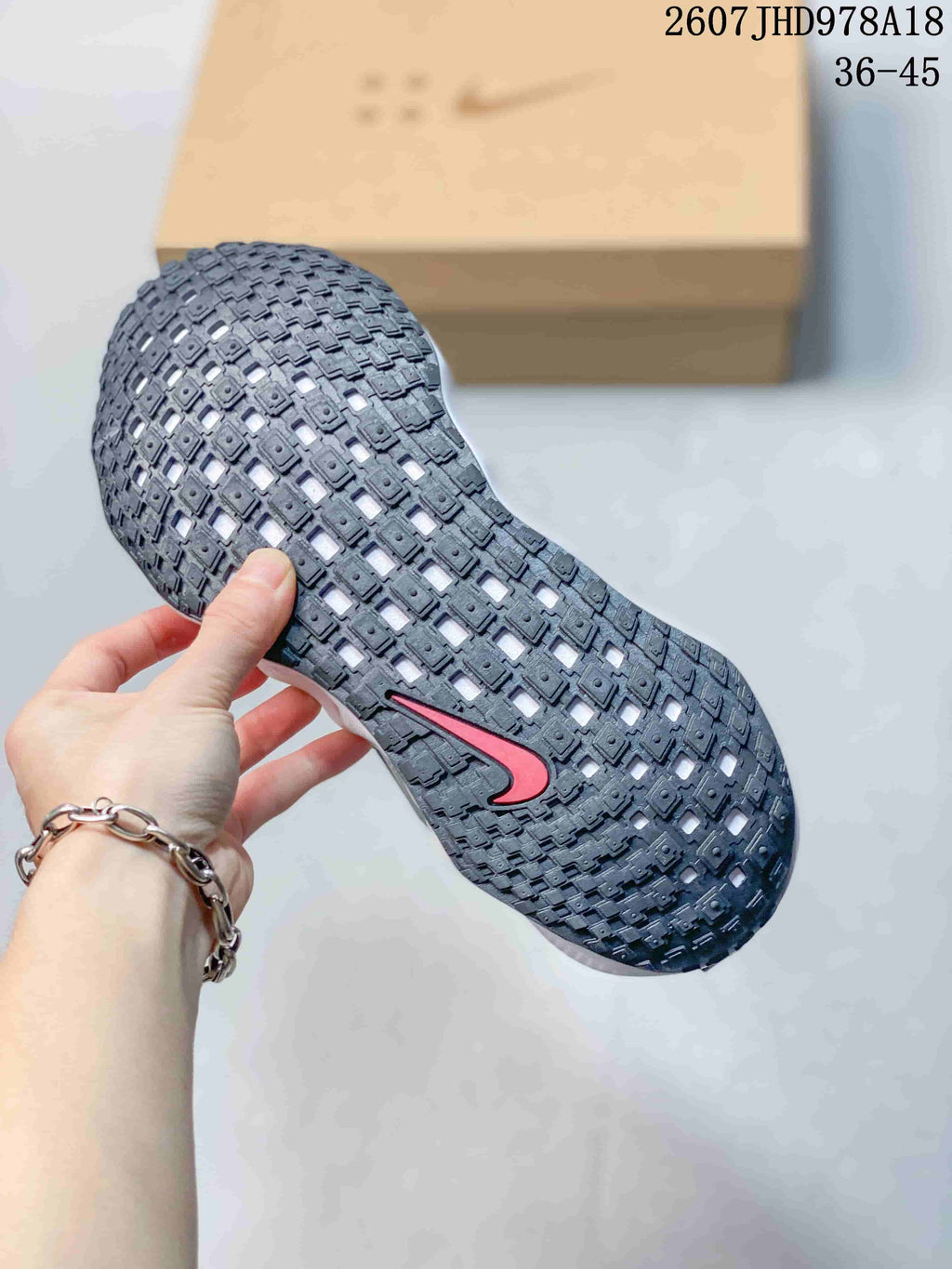 Close-up of the black textured outsole showing a repeating traction pattern and red Nike Swoosh detail.
