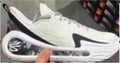 White and black basketball shoe shown from the side, with a sculpted sole and visible cushioning window.