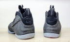 Rear view of black and grey Nike Air Foamposite Pro Fleece high-top sneakers