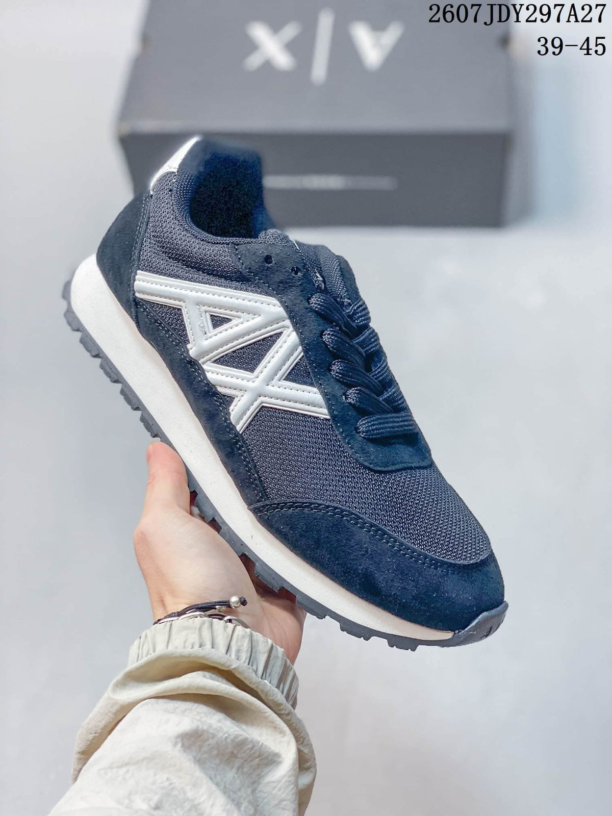 Navy low-top sneaker with a white geometric side logo and textured outsole.