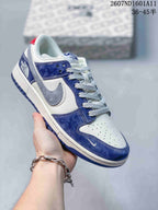 Angled side view highlighting the blue and white upper, gray swoosh-style overlay, textured laces, and heel branding.