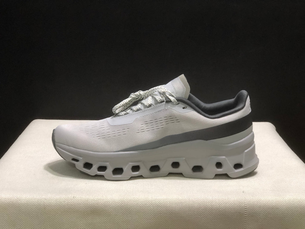 Lateral profile of one sneaker showing the streamlined upper, dark heel band, and segmented outsole.