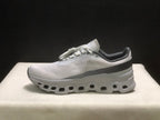 Lateral profile of one sneaker showing the streamlined upper, dark heel band, and segmented outsole.