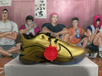 Side view of a metallic gold Nike basketball shoe with black trim and a red charm