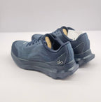 Rear view of the dark blue Alo sneaker pair with visible heel details and textured upper panels.