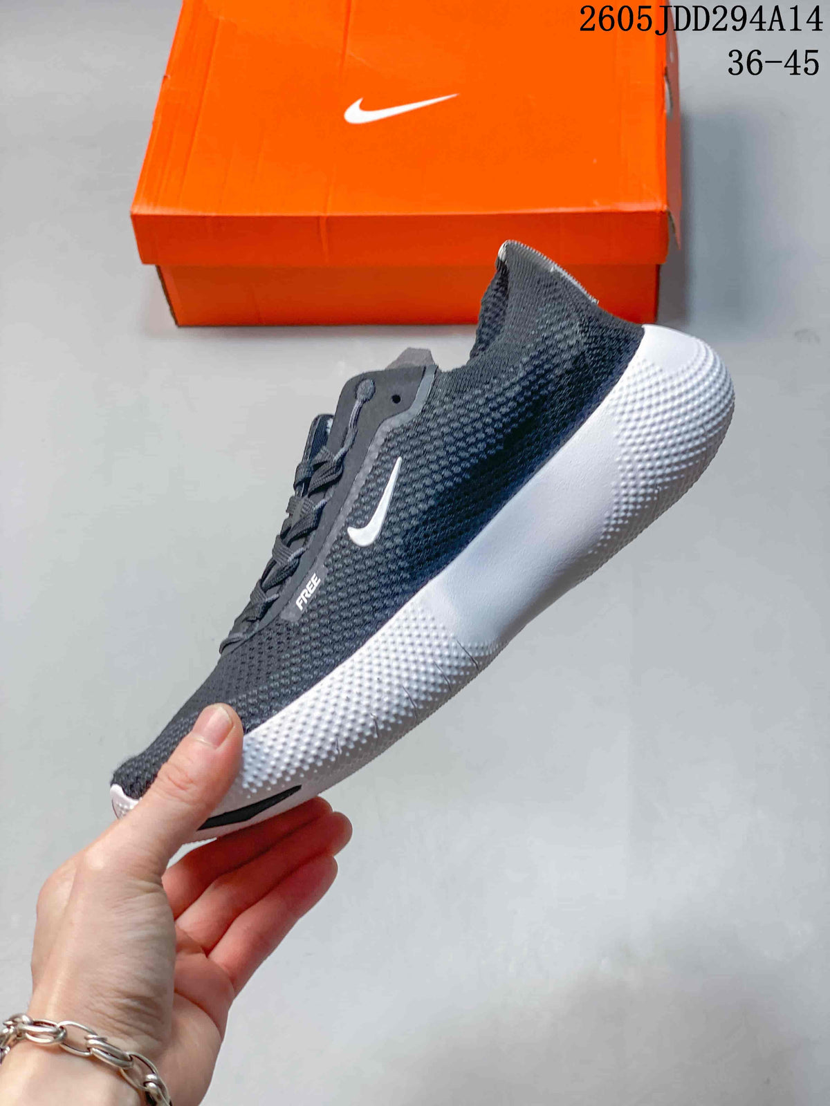 Side profile of a dark gray Nike Free sneaker showing the white Swoosh, lace panel, knit-textured upper, and white grooved sole.