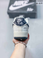 Rear view of the white sneaker showing the padded heel, tongue branding, dark patterned heel detail, and layered outsole.