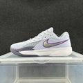 Side view of a white Nike Zoom sneaker with gray forefoot detailing, a purple-outlined Swoosh and a white midsole.