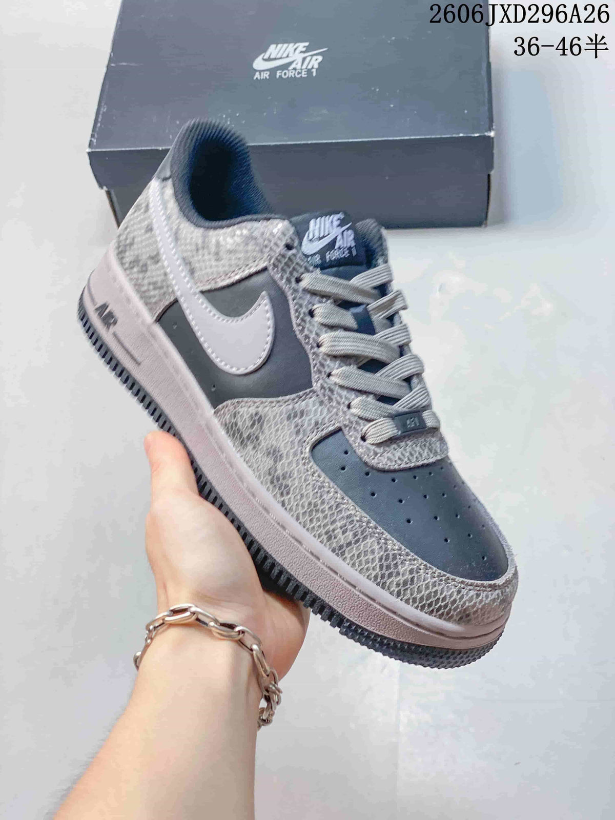 Angled side view of the grey and white low-top sneaker with a contrasting Swoosh and rubber outsole.