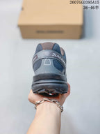 Rear view of a dark gray Salomon trail shoe showing the padded heel collar, heel overlay, and lugged outsole.