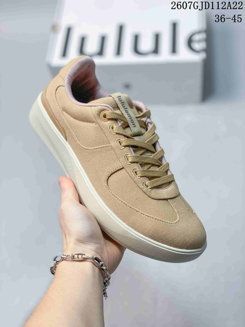 Angled side view of the tan lululemon sneaker showing its low-top profile, stitched panels and textured outsole.