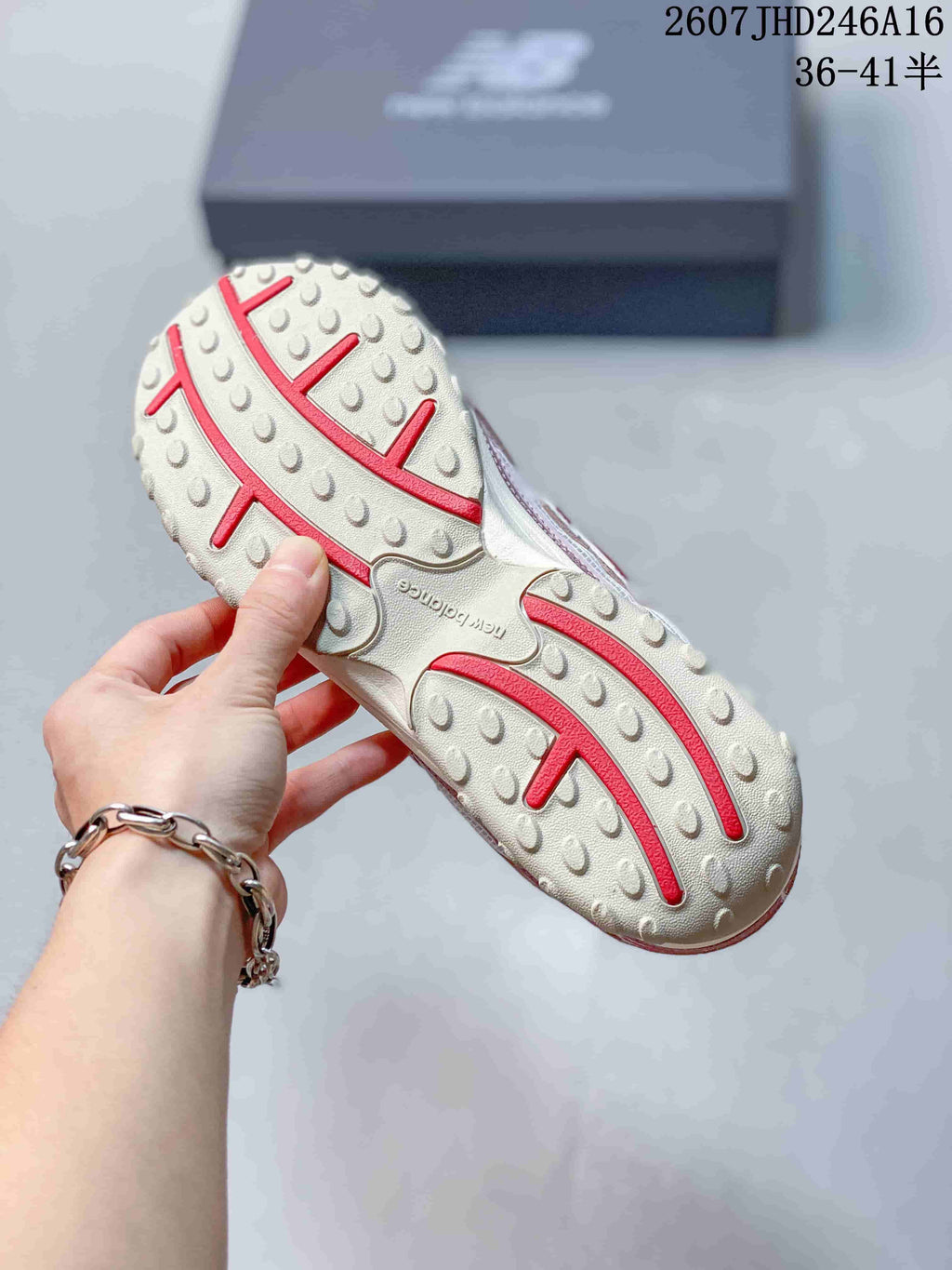 Close view of the textured off-white outsole with red accent channels and raised tread details.