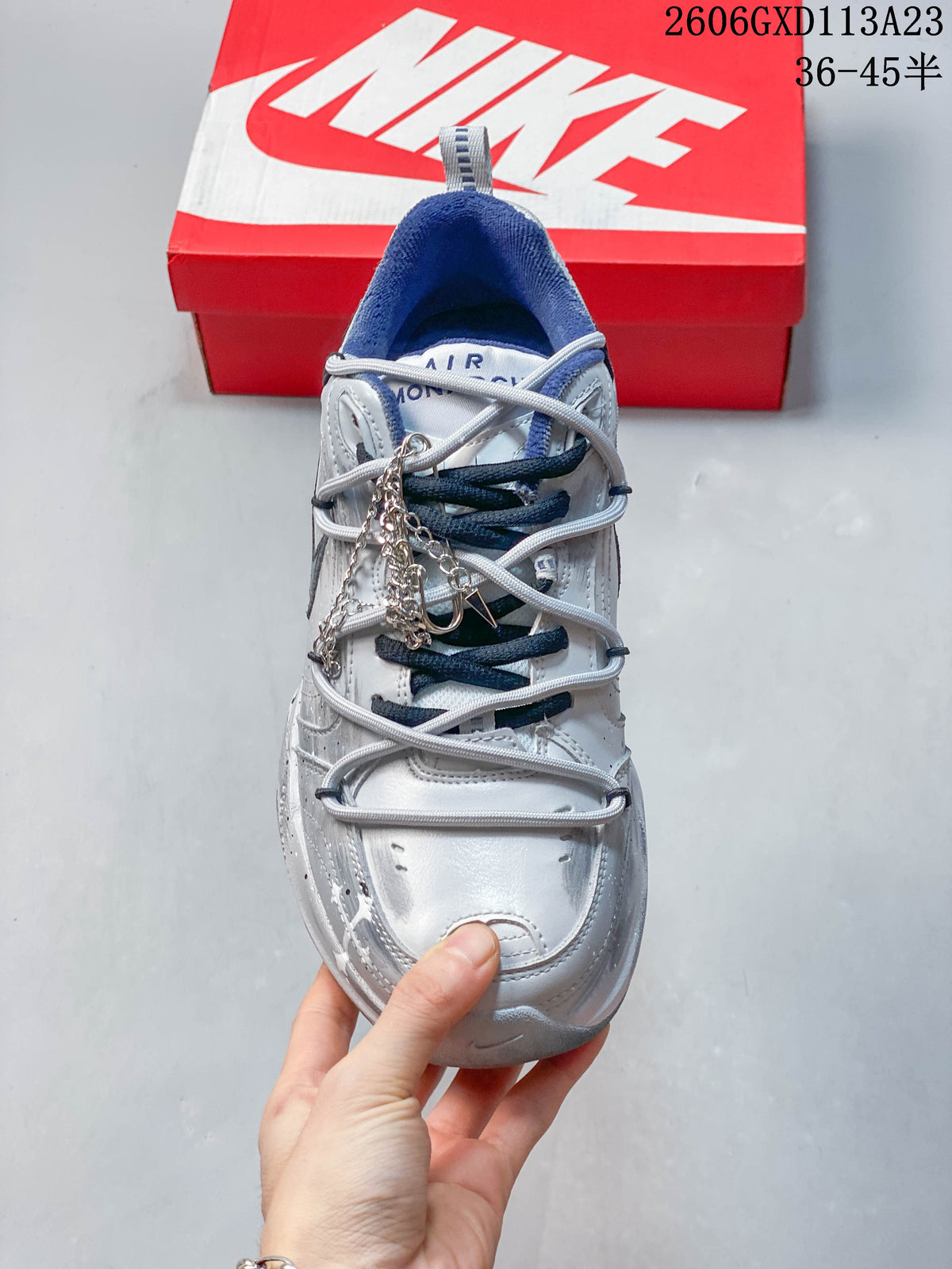 Top view of the sneaker showing mixed-color laces and a decorative chain detail.