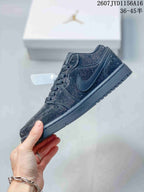 Side profile of a black Jordan sneaker showing the tonal Swoosh and low-top silhouette.