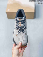 Top view of a gray sneaker with black laces, a textured toe area, and contrasting tongue details.
