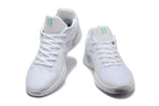 Pair of white Nike Sabrina basketball shoes shown from the front with teal tongue accents.