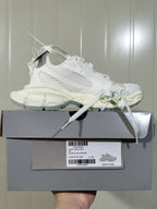 White mesh sneaker displayed on a gray shoe box, with the box label visible.
