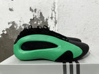 Side view showing the sculpted green panel and black inset on an Adidas basketball shoe.