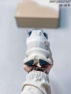 Rear view of a white and gray sneaker showing the padded heel, On branding, and split sole structure.