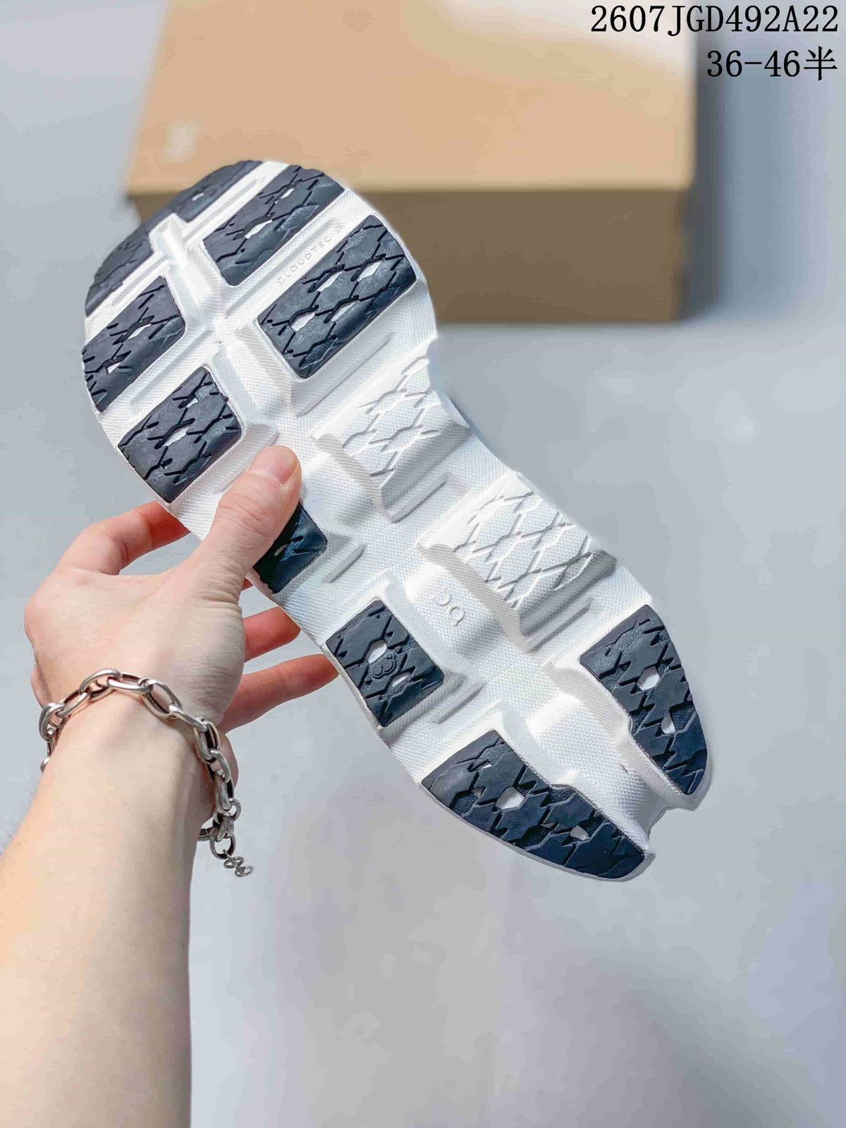 Close view of the shoe outsole showing segmented dark and white tread sections; the image displays style code 2607JGD492A22 and size range 36–46.