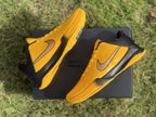 Angled overhead view of both yellow and black basketball shoes.