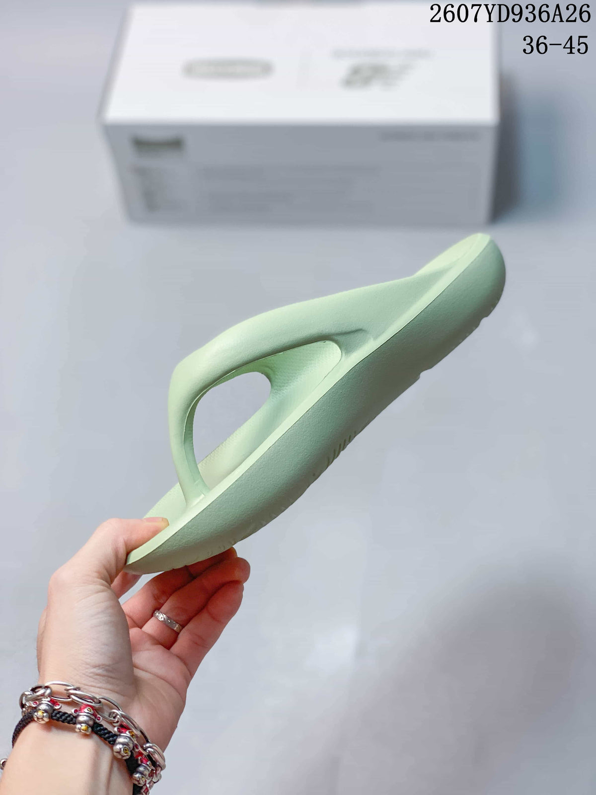 Side profile of a pale green New Balance thong sandal showing the molded sole and raised upper.