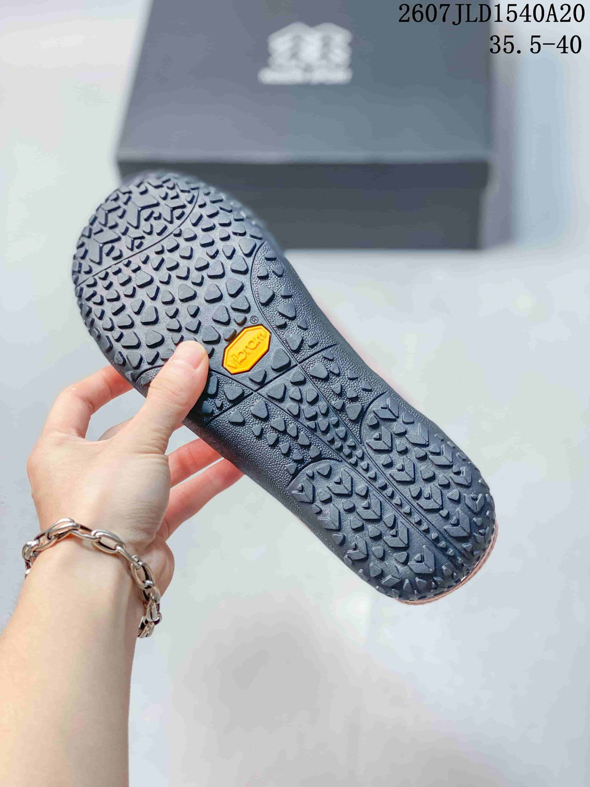 Close-up of the patterned black sneaker outsole with a visible yellow Vibram mark.