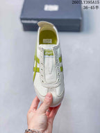 Top view of the sneaker showing the tongue, eyelets, stitched vamp, and green side detailing.