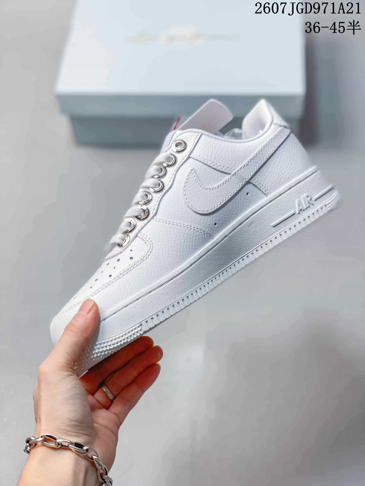 Side profile of the white low-top sneaker showing the Swoosh, perforated toe, lace-up design, and layered sole.