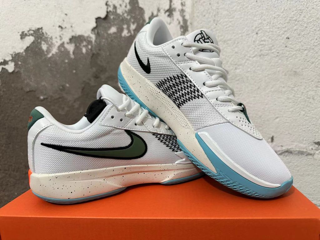 Pair of white Nike basketball shoes shown from the side, with green and black accents and blue outsoles