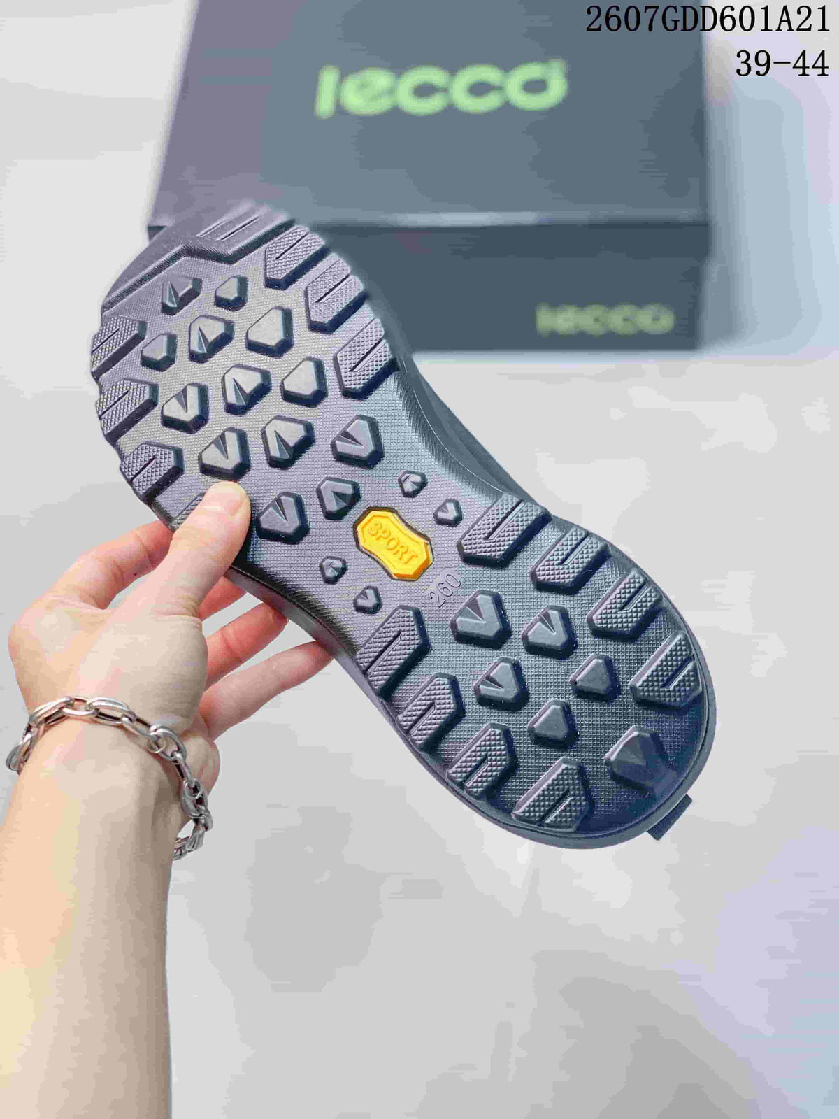 Close view of the patterned black outsole with raised tread blocks and a yellow outsole insert.