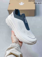 Angled view of the white and navy DESCENTE slip-on sneaker with textured upper panels