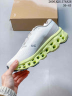 Side view of the shoe showing the white upper, On logo and lime segmented midsole with open geometric sections.