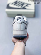 Rear view of a white Nike Air Force 1 sneaker with navy lining and heel branding.