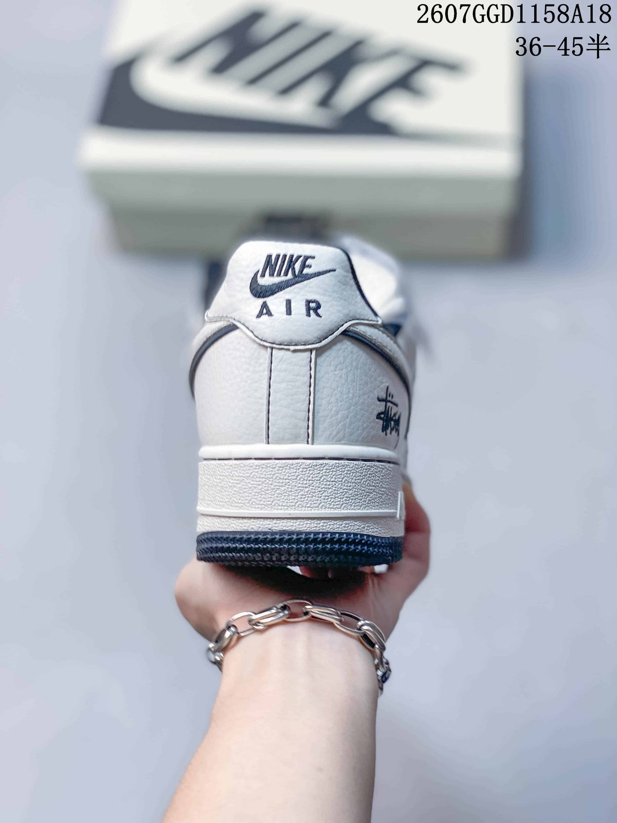 Rear view of a white Nike Air Force 1 sneaker with navy lining and heel branding.
