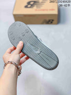Close-up of the gray textured outsole with circular traction details and New Balance branding.