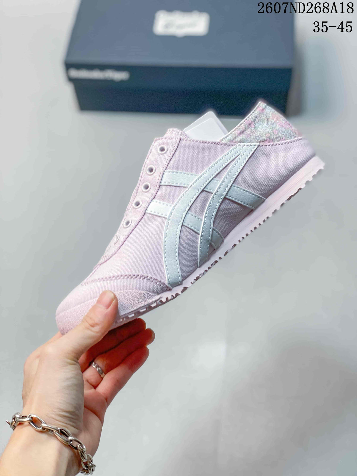 Side profile of the pink low-top sneaker showing the light-colored side stripes, rounded toe and low rubber sole.