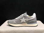 Side profile of a grey sneaker showing the large white star emblem, layered upper panels, cream midsole, and black outsole.