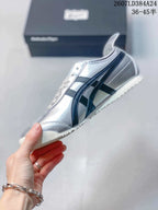 Side profile showing the silver upper, black stripes, laces and low-top shape.