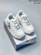 Pair of white MLB low-top sneakers with blue NY side lettering, patterned laces and a chunky outsole displayed on an MLB shoe box.