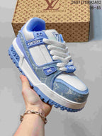 Close-up of a white and light blue low-top sneaker showing layered panels and a textured outsole