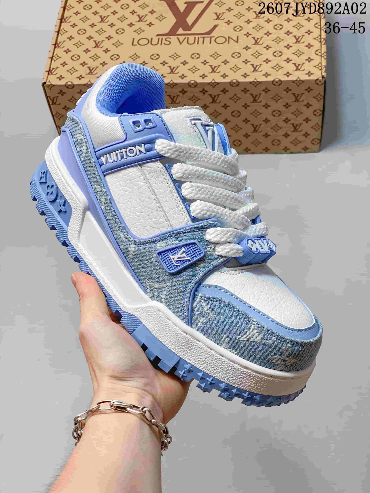 Close-up of a white and light blue low-top sneaker showing layered panels and a textured outsole