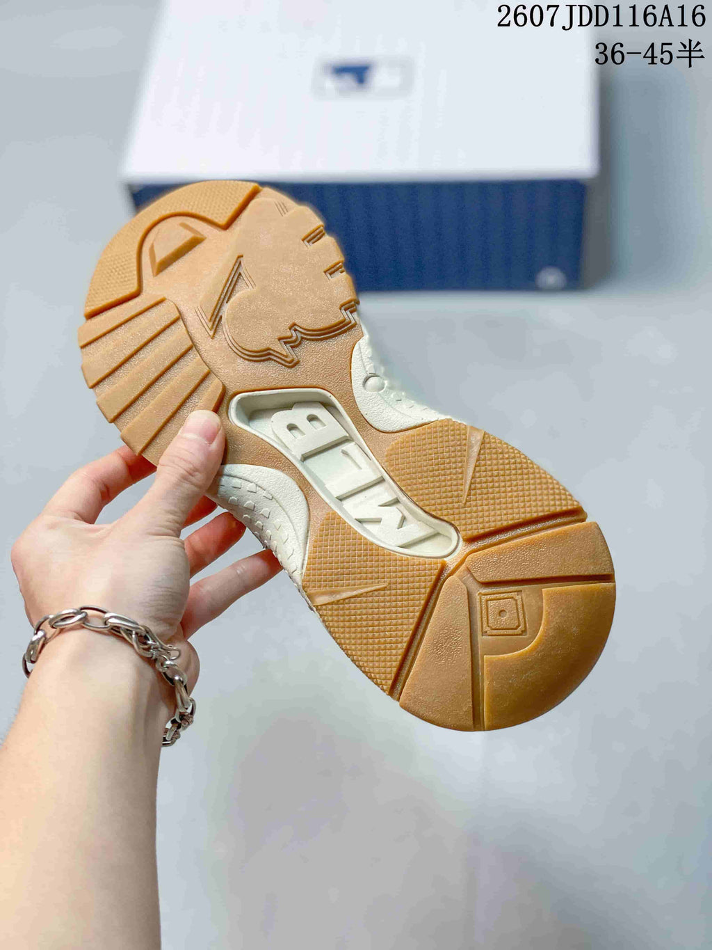 Close-up of the sneaker outsole showing a gum-colored tread pattern and segmented traction areas.