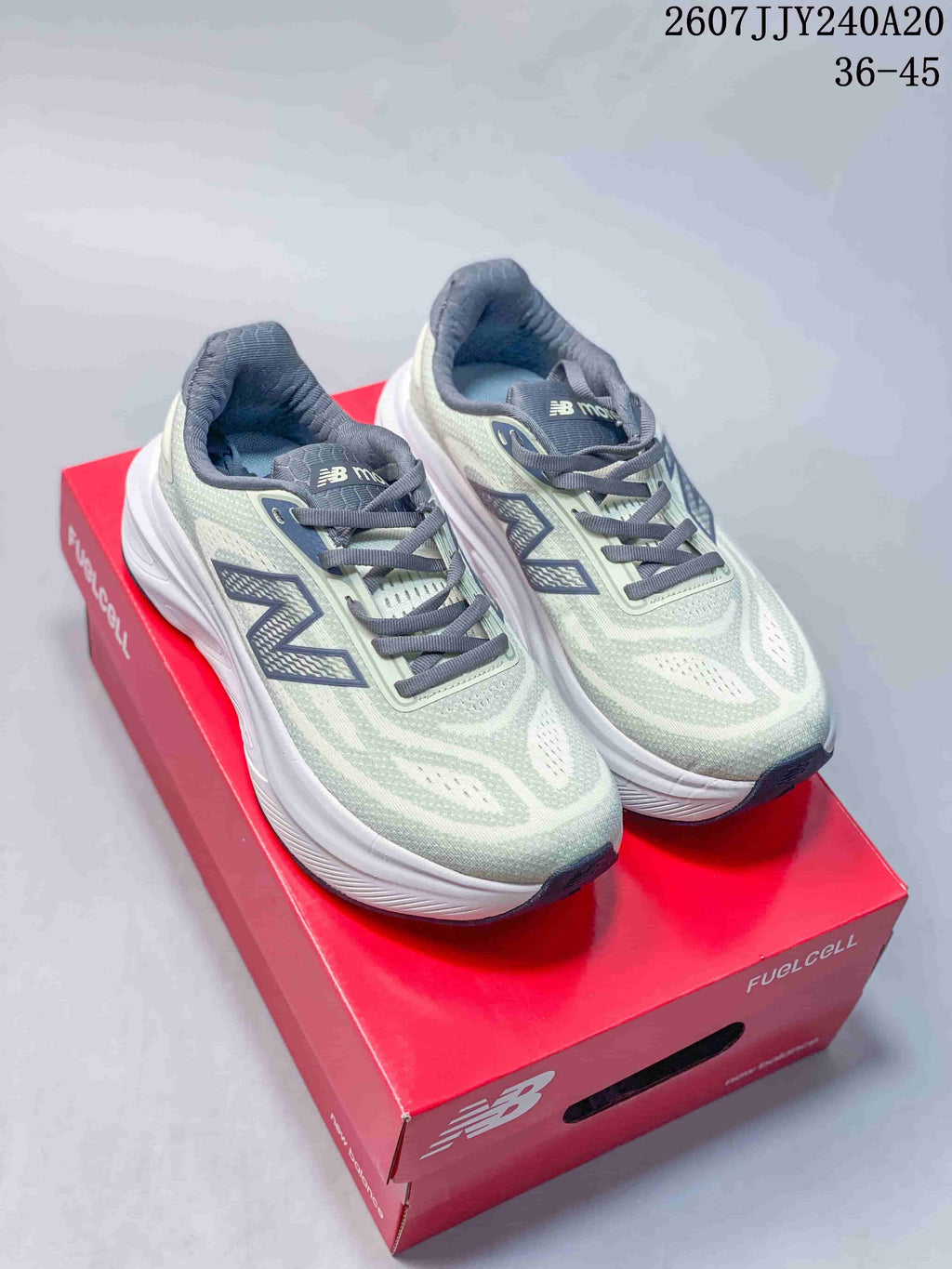 Pair of pale green and gray New Balance Fresh Foam X More shoes displayed on a red shoebox.
