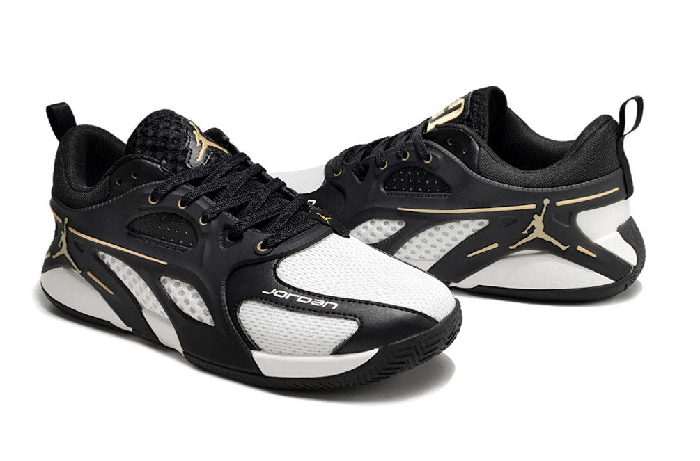 Side view of black and white Jordan Heir shoes with gold-tone details