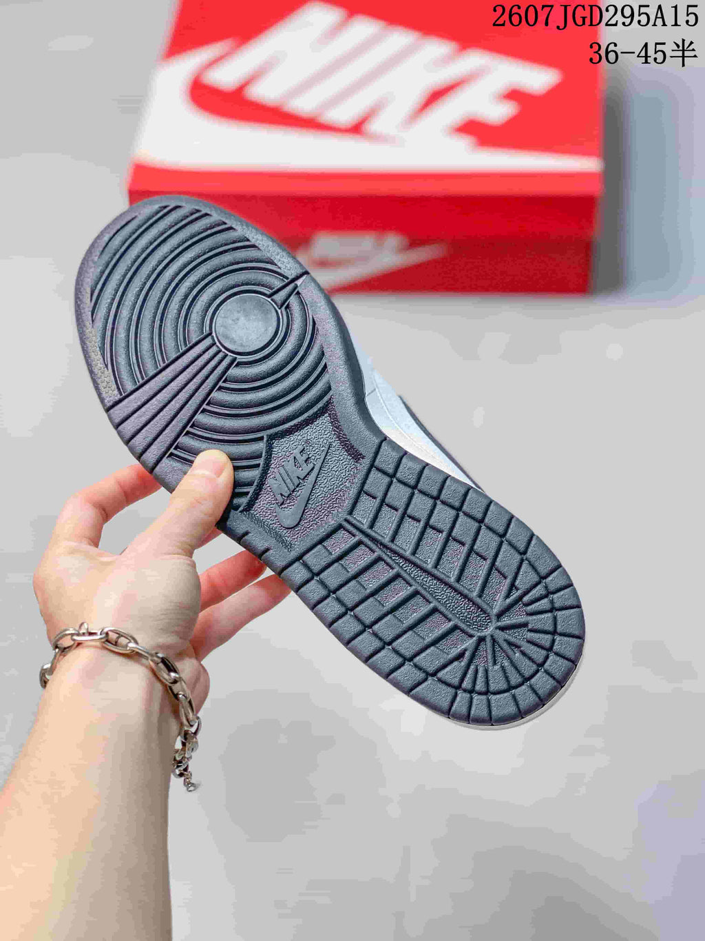 Bottom view of the sneaker showing the dark textured rubber outsole and circular traction pattern.