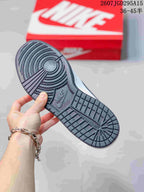 Bottom view of the sneaker showing the dark textured rubber outsole and circular traction pattern.