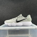 Side view of a gray Nike low-top sneaker with a black Swoosh and white ridged sole.