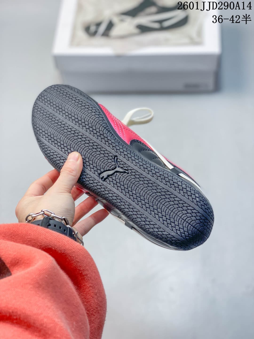 Close view of the patterned black rubber outsole with a PUMA logo and red side detailing.