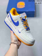 Angled side view showing the white sneaker upper, blue Swoosh, yellow collar lining, blue heel details, and yellow outsole.